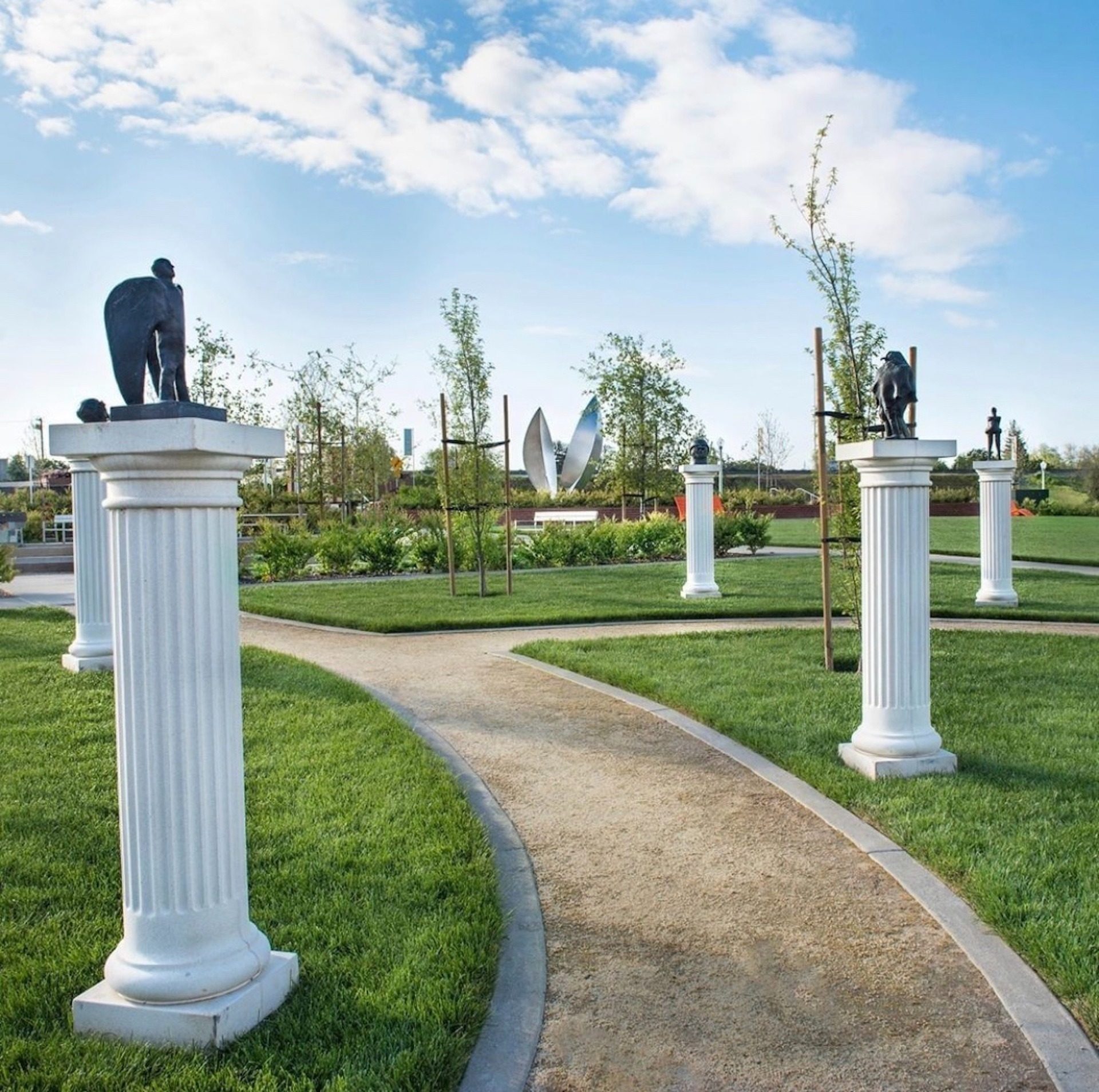 Manicured lawn and garden with sculpture-lined pathway