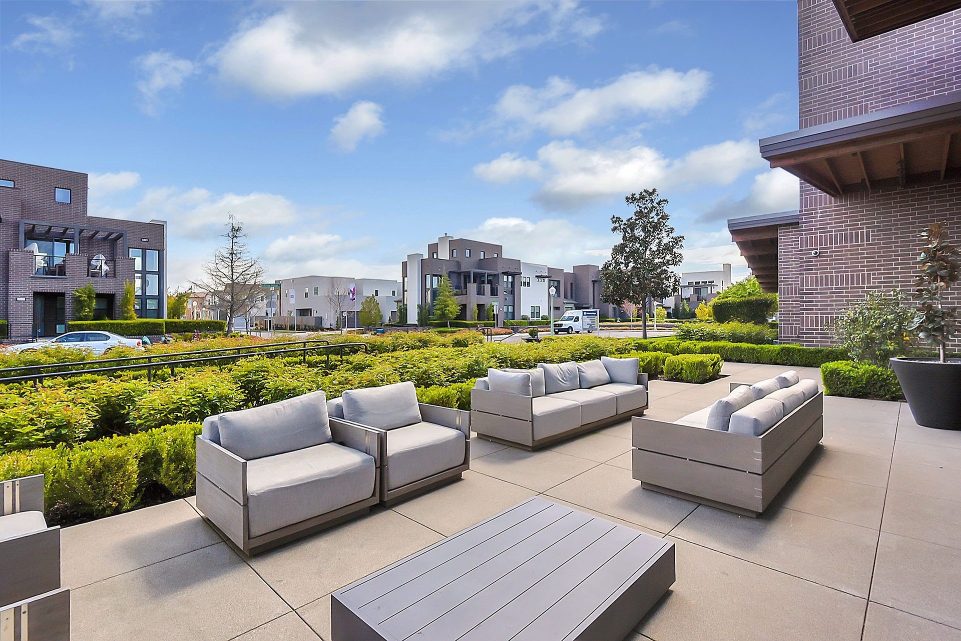 Commercial courtyard patio with lounge seating and manicured hedges