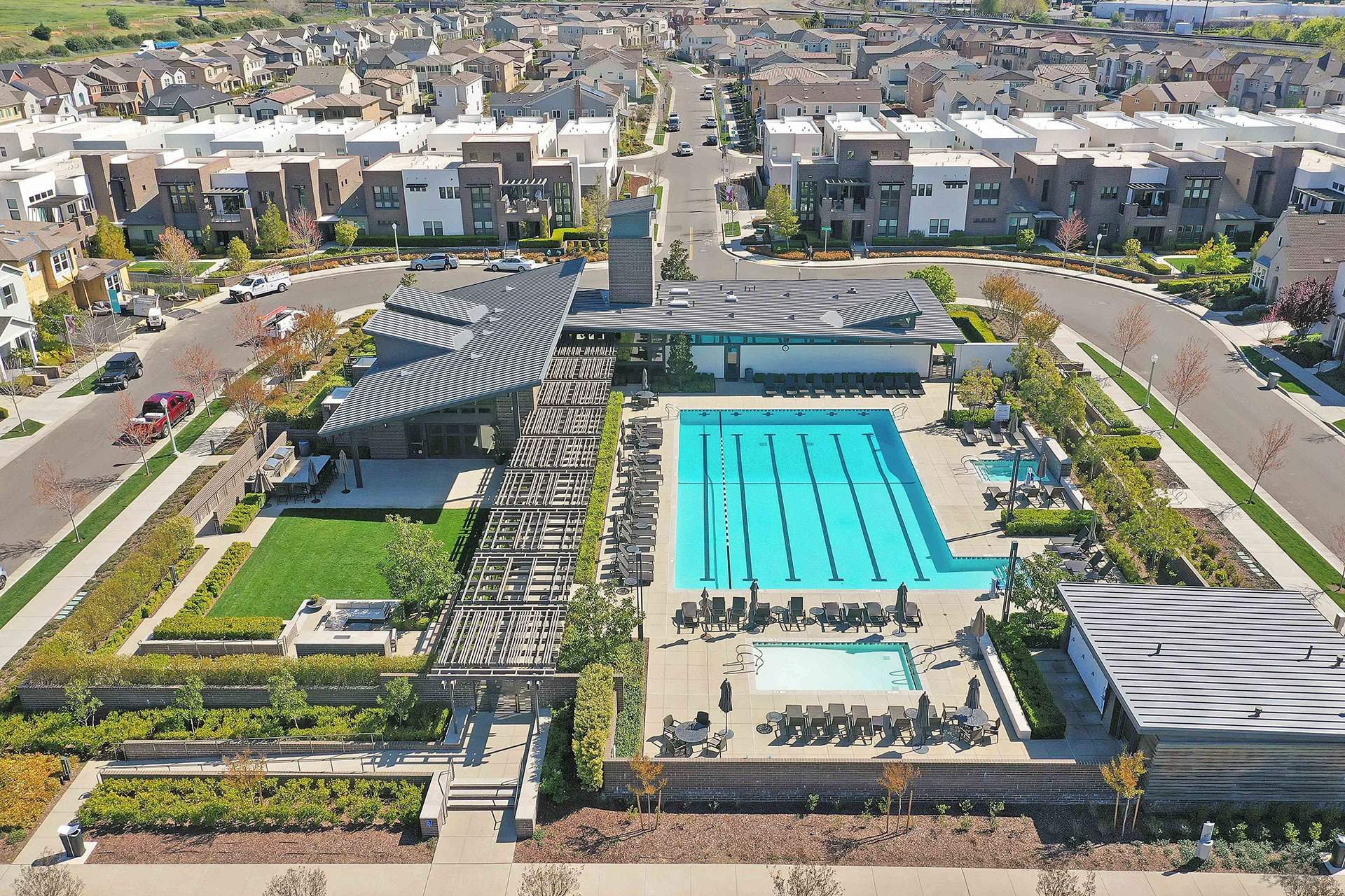 Aerial view of a resort-style community pool and clubhouse landscape
